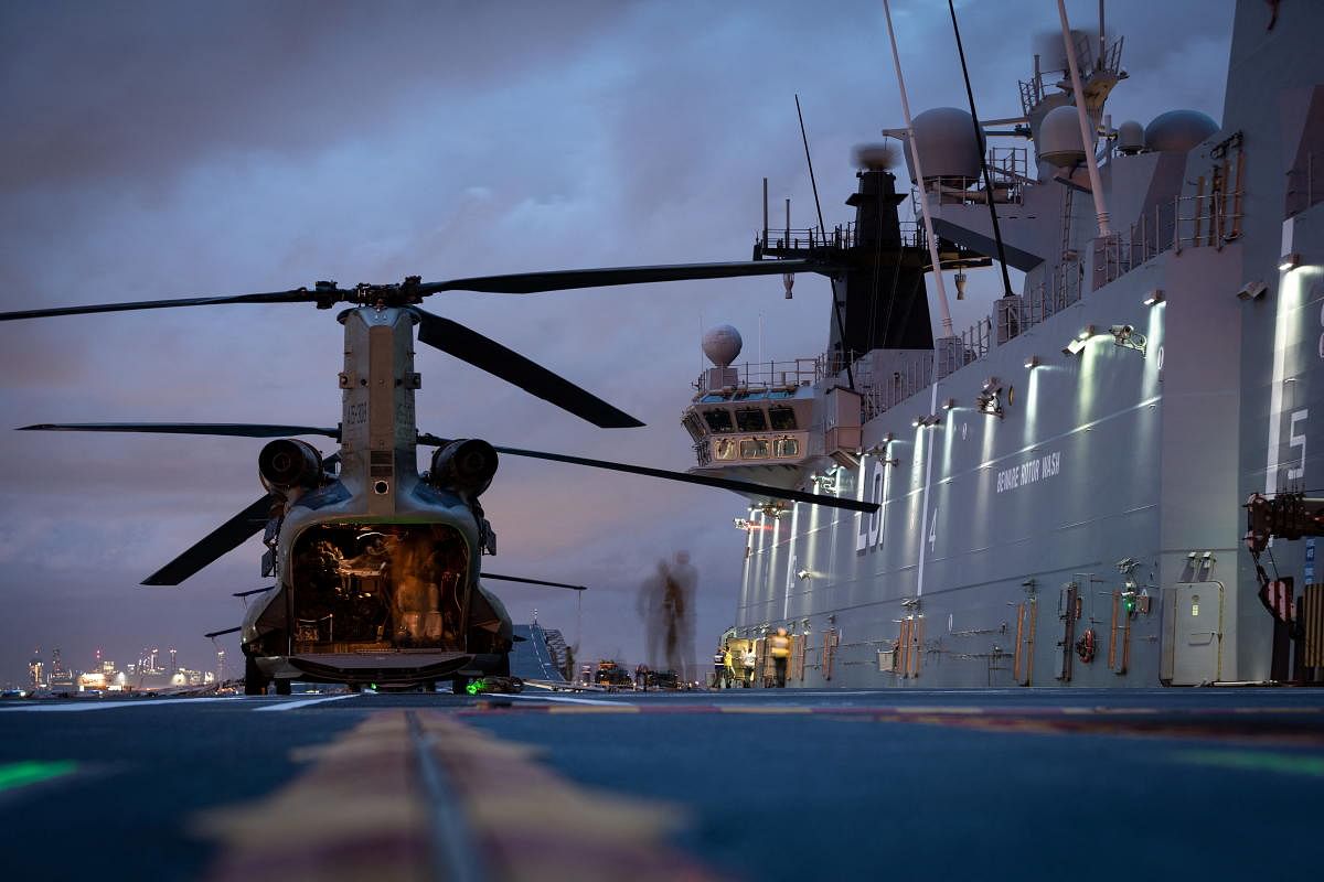 HMAS Adelaide embarks Australian Army CH-47 Chinook Heavy-Lift Helicopters before departing the port of Brisbane for Tonga to assist in relief efforts. Credit: Reuters Photo