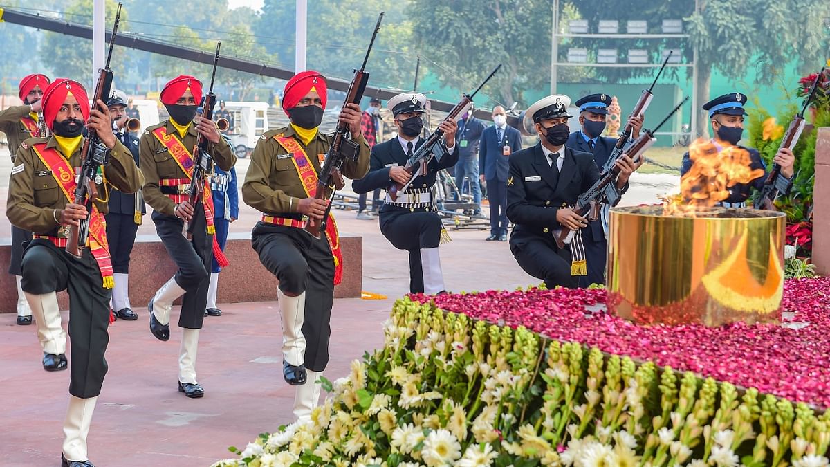 Security personnel pay gun salute to Amar Jawan Jyoti flame at India Gate, during a ceremony to merge Amar Jawan Jyoti flame with flame at National War Memorial, in New Delhi. Credit: PTI Photo