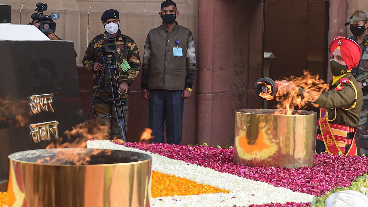 A torch being lit from Amar Jawan Jyoti flame to be taken to National War Memorial for merging it with the flame at the Memorial, in New Delhi. Credit: PTI Photo