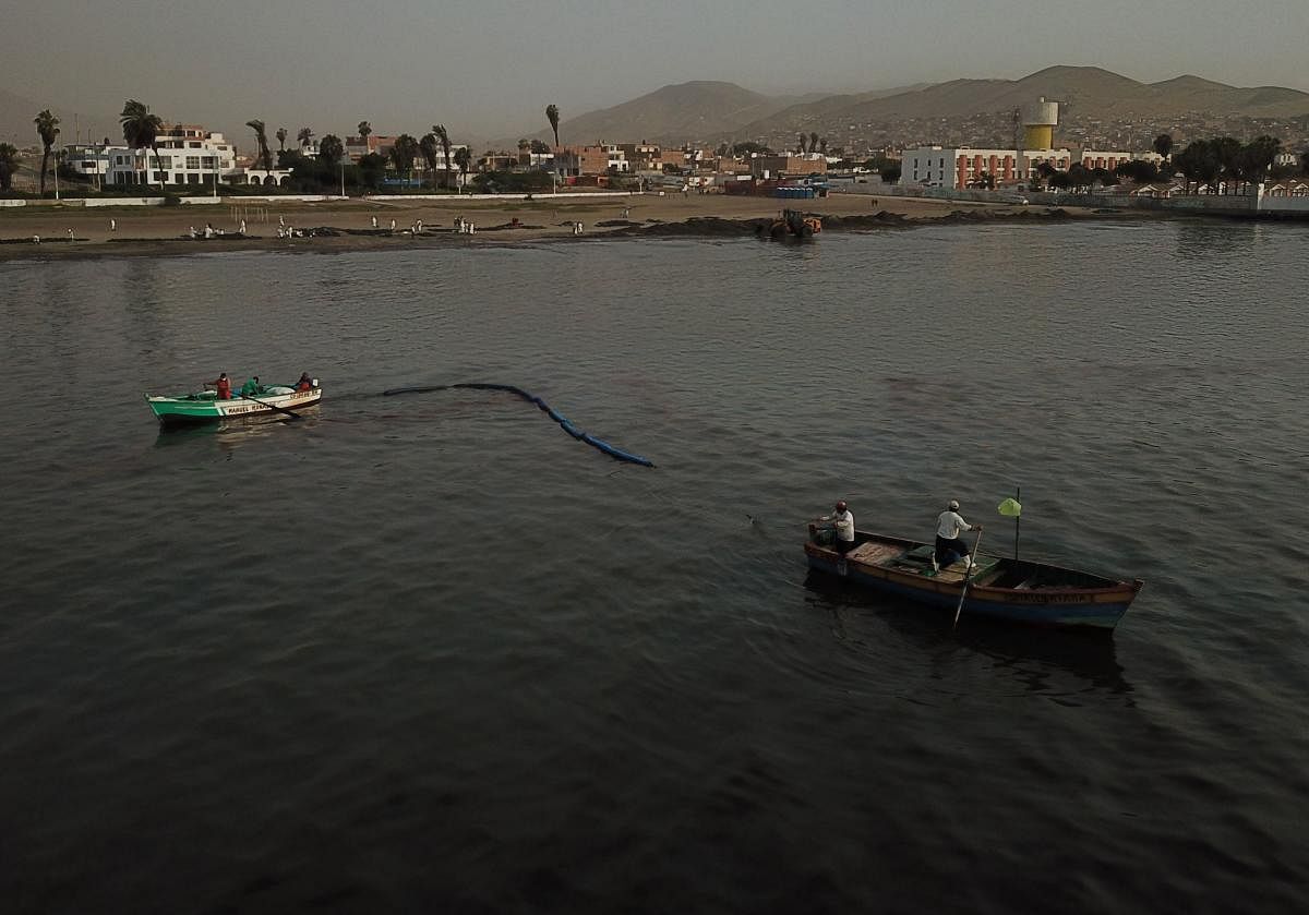 Aereal view of boats gathering oil on the sea surface from a beach annexed to the summer resort town of Ancon, northern Lima, on January 20, 2022 after a spill which occurred during the offloading process of the Italian-flagged tanker