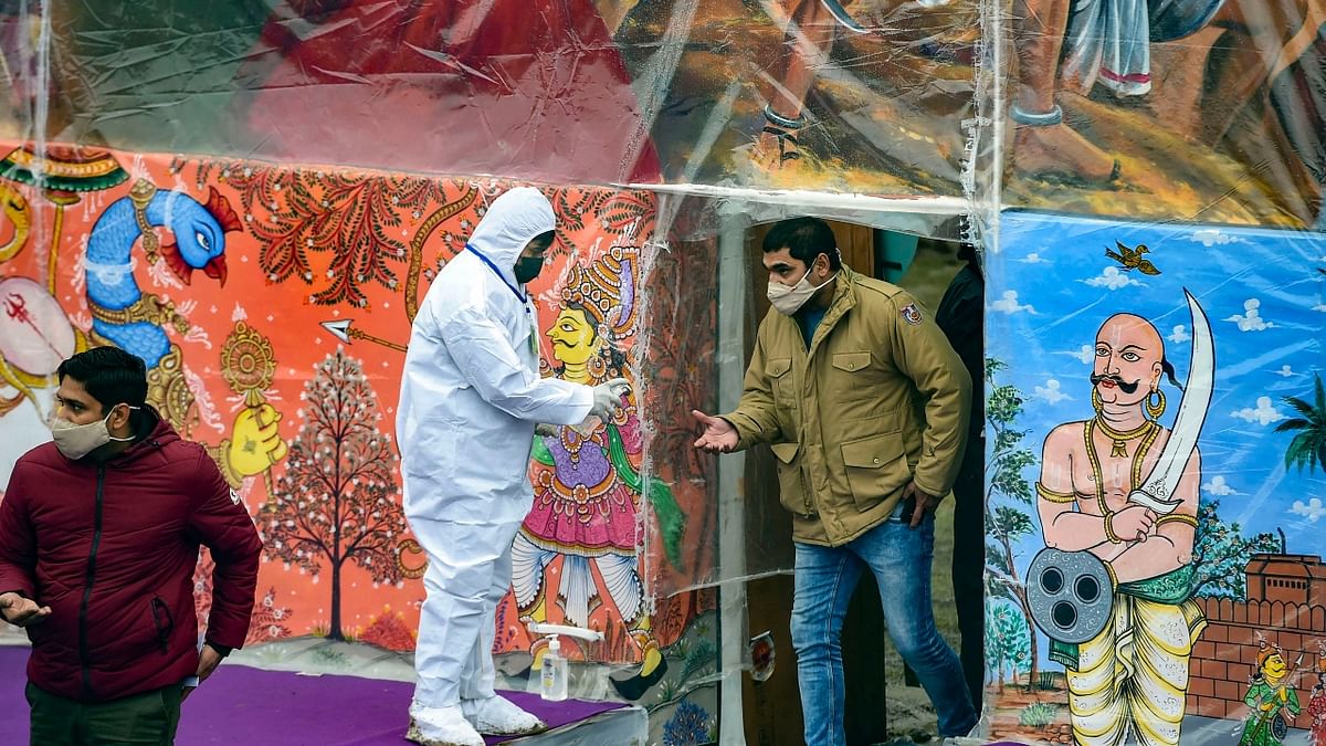 A worker provides hand sanitiser to a person during the full dress rehearsal of the Republic Day Parade 2022 at the Rajpath in New Delhi. Credit: PTI Photo