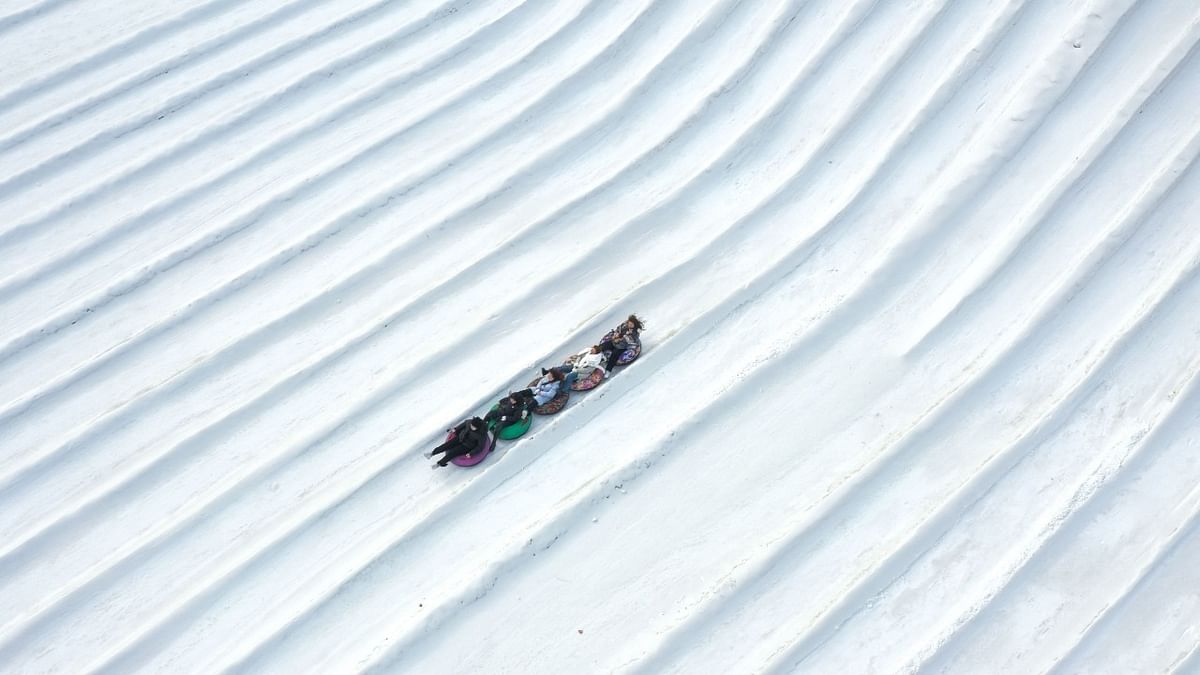 This aerial photo taken on January 25, 2022 shows people enjoying a tube ride in the snow at a park in Shenyang in China's notheastern Liaoning province. Credit: AFP Photo