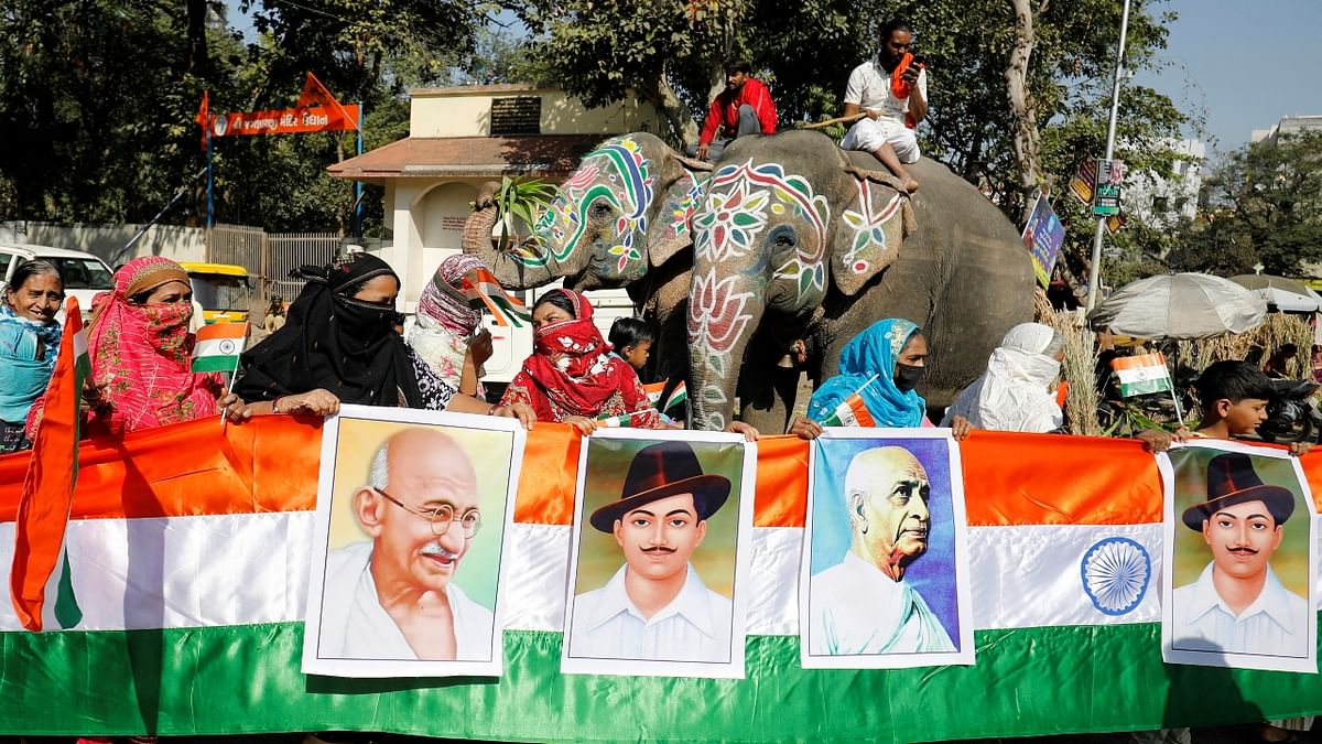 Women hold a 73-feet long tri-colour flag with posters of India's freedom fighters during a ceremony to cerebrate Republic Day in Ahmedabad. Credit: PTI Photo