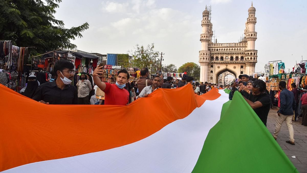 People hold the national flag on the eve of Republic Day in front of the Charminar in Hyderabad. Credit: PTI Photo