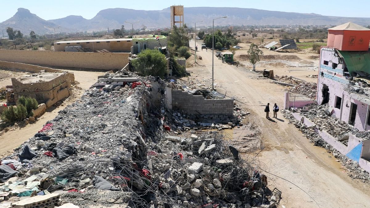 Yemenis stand next to a building reported to be a prison destroyed in a Saudi-led airstrike in the Huthi stronghold of Saada in northern Yemen. Credit: AFP Photo