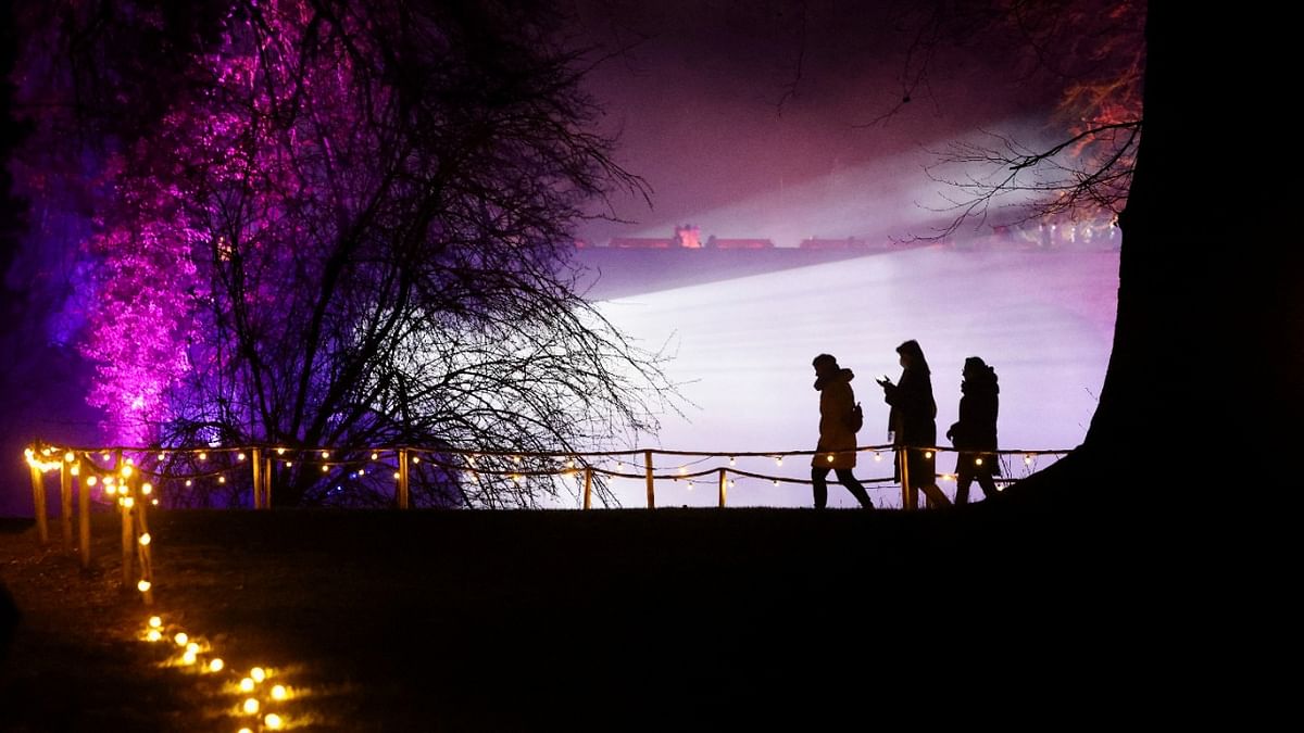 People walk through Nature Illuminated experience depicting immersive and sensorial lights and sounds effects on the theme of the four seasons in the park of the Groot-Bijgaarden Castle, near Brussels, Belgium. Credit: Reuters Photo