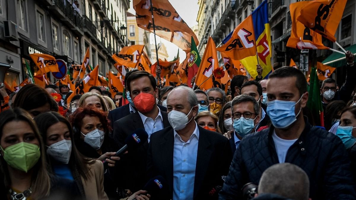 Opposition leader and president of the Social Democratic Party (PSD) Rui Rio (C) walks surrounded by journalists and supporters during a street campaign rally ahead of Portugal's general elections, in Lisbon. Credit: AFP Photo