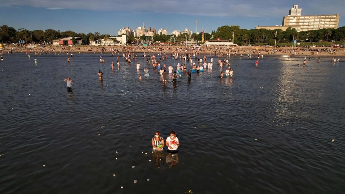 In this aerial view people give offerings to Yemanja, the Goddess of the Sea of the Afro-American religion Umbanda, at Ramirez beach in Montevideo. Credit: AFP Photo
