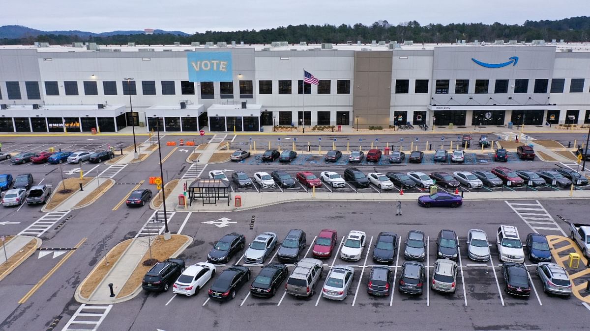 A banner with “VOTE” on it is displayed facing the employee parking lot at an Amazon facility on the first day of the unionizing vote, in Bessemer, Alabama, US. Credit: Reuters Photo