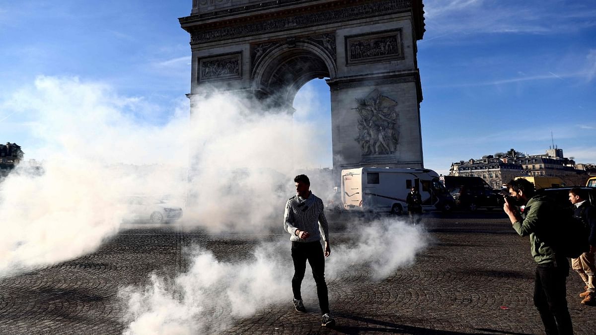 Anti-vaccine protesters navigate their way through Place Charles De Gaulle (Place de l'Etoile) in Paris. Credit: AFP Photo