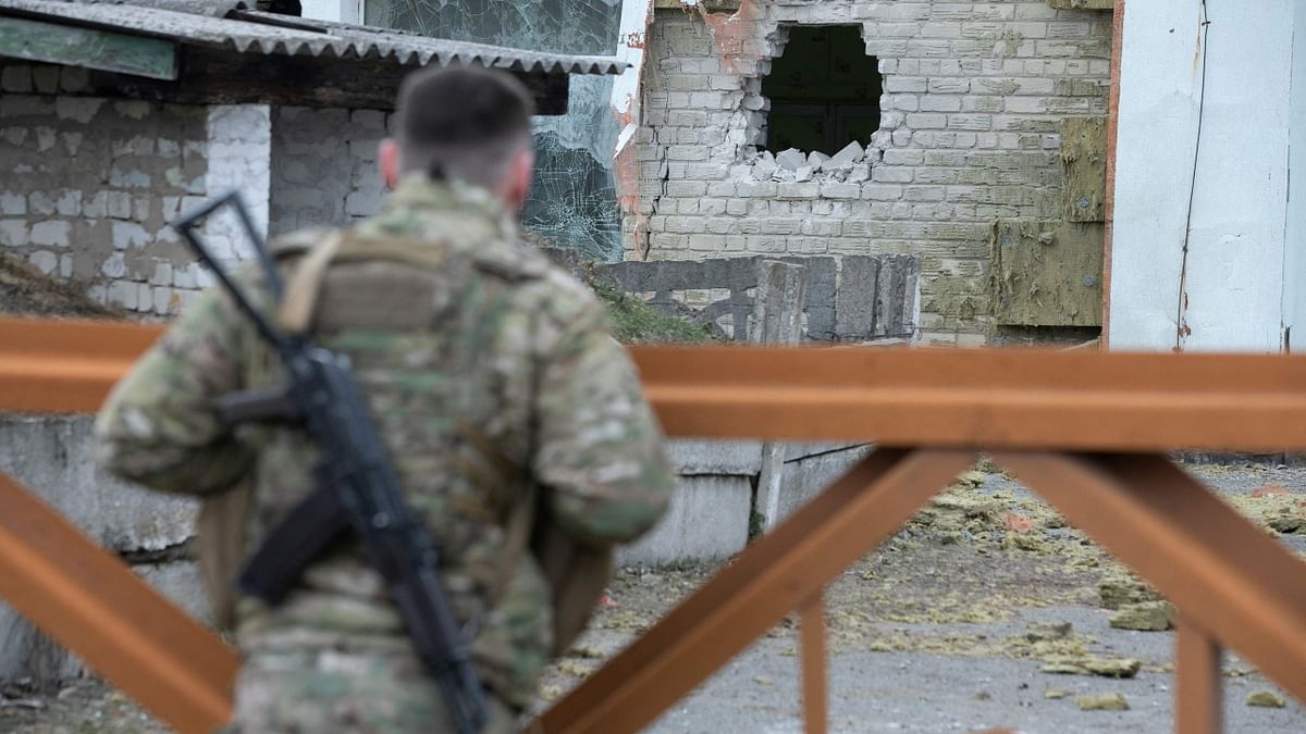 A Ukrainian soldier looks at debris after the reported shelling of a kindergarten in the settlement of Stanytsia Luhanska. Credit: AFP Photo