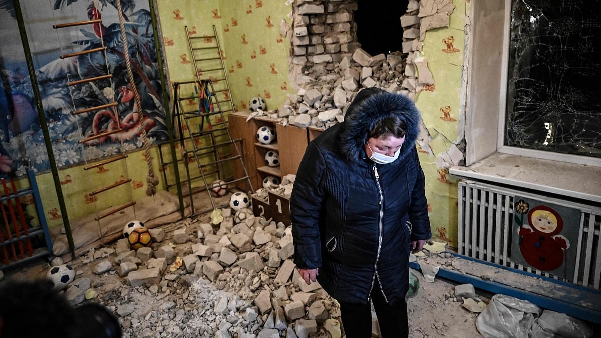 A woman stands among debris after the reported shelling of a kindergarten in the settlement of Stanytsia Luhanska, Ukraine. Credit: AFP Photo