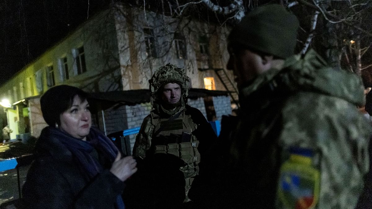 Service members of the Ukrainian armed forces talk with a local resident outside of a kindergarten, which, according to Ukraine's military officials, was damaged by shelling, in Stanytsia Luhanska, in the Luhansk region, Ukraine. Credit: Reuters Photo