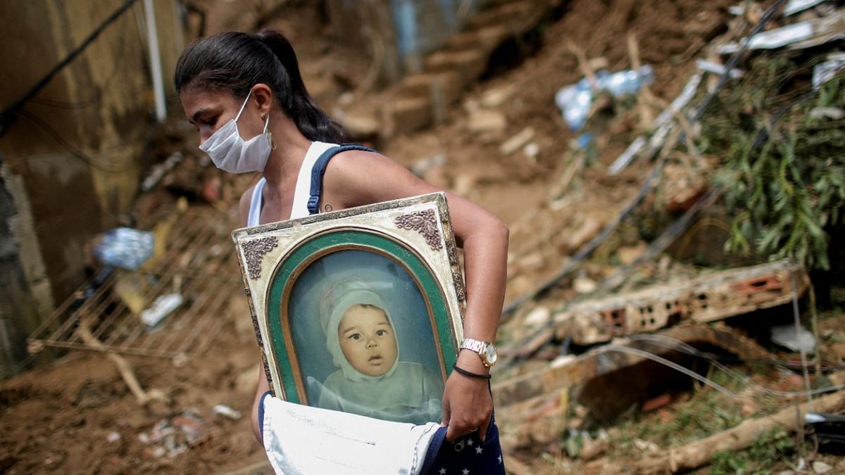 A woman carries a picture at the site of a mudslide at Morro da Oficina after pouring rains in Petropolis, Brazil. Credit: Reuters Photo
