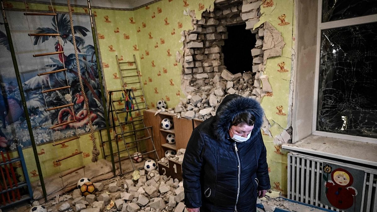 A woman stands inside among debris after the reported shelling of a kindergarten in the settlement of Stanytsia Luhanska, Ukraine. Credit: AFP Photo