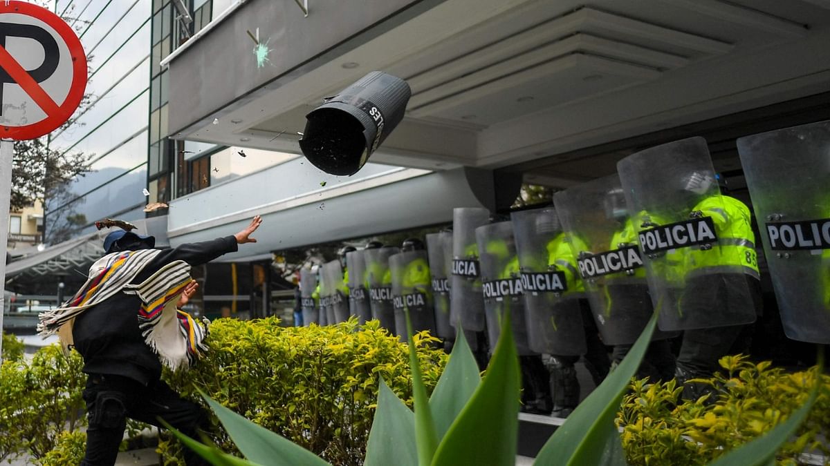 An anti-fascism protester throws a trash can at riot police in front of an hotel where the 1st Regional Meeting 'For Democracy and Freedoms' organised by the Madrid Forum, a group of political forces that identify with the right-wing, is held in Bogota. Credit: AFP Photo