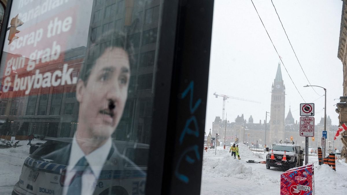 A graffitied image of Prime Minister Justin Trudeau is seen as city employees clean up Wellington Street in front of Parliament Hill, previously occupied by the Freedom Convoy, in Ottawa. Credit: AFP Photo