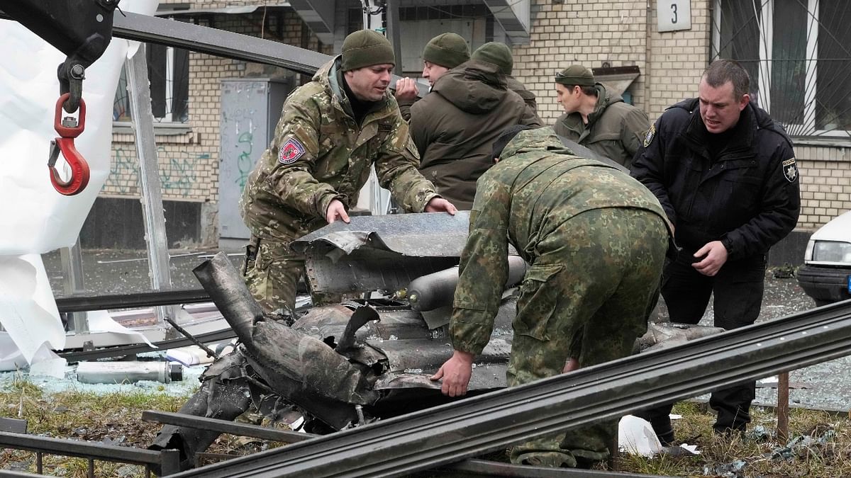 Workers prepare to load the debris of a rocket onto a truck the aftermath of Russian shelling in Kyiv, Ukraine. Credit: AP Photo