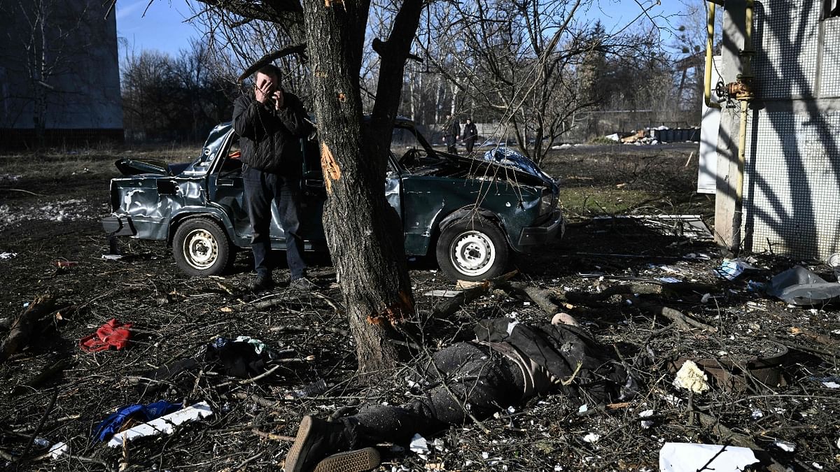 A man reacts as he stands by a body after heavy bombings on the eastern Ukraine town of Chuguiv on February 24, 2022. Credit: AFP Photo