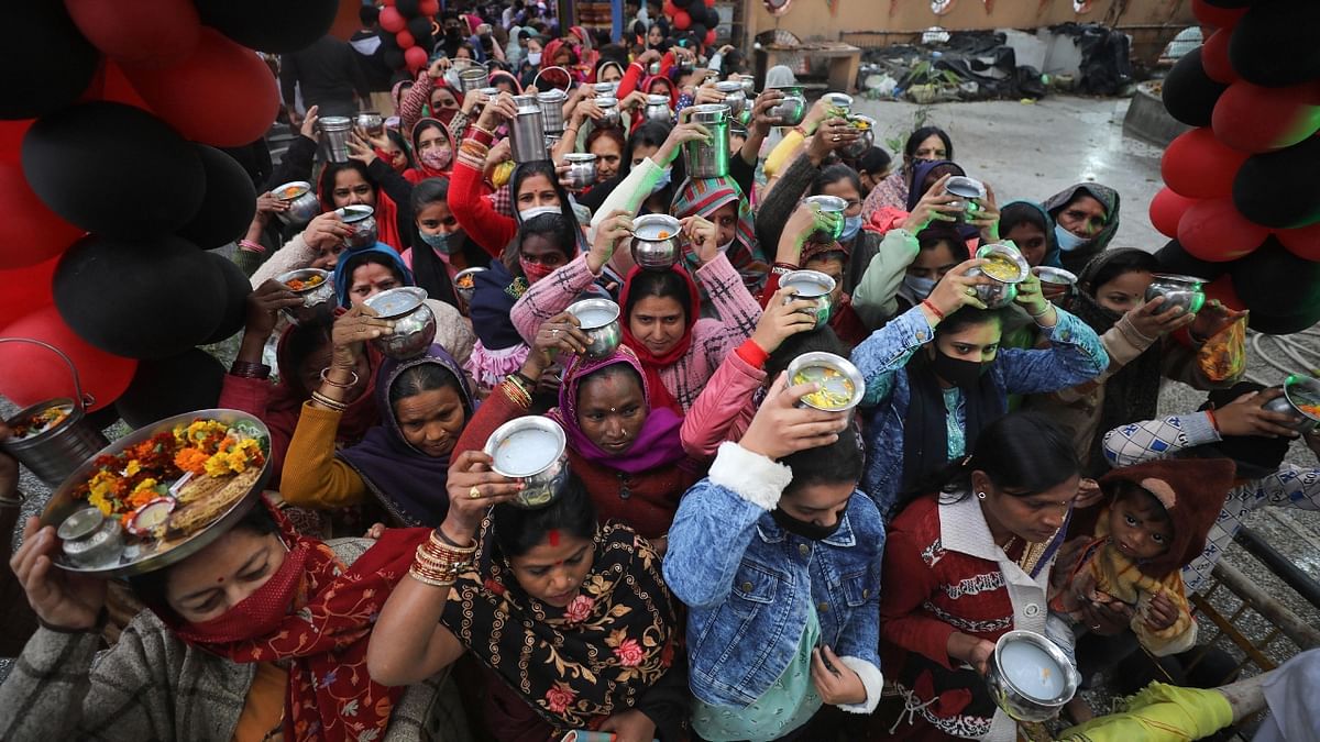 Devotees carry milk and sweets as they wait to offer prayers to Lord Shiva on the occasion of Maha Shivratri, in Jammu. Credit: PTI Photo