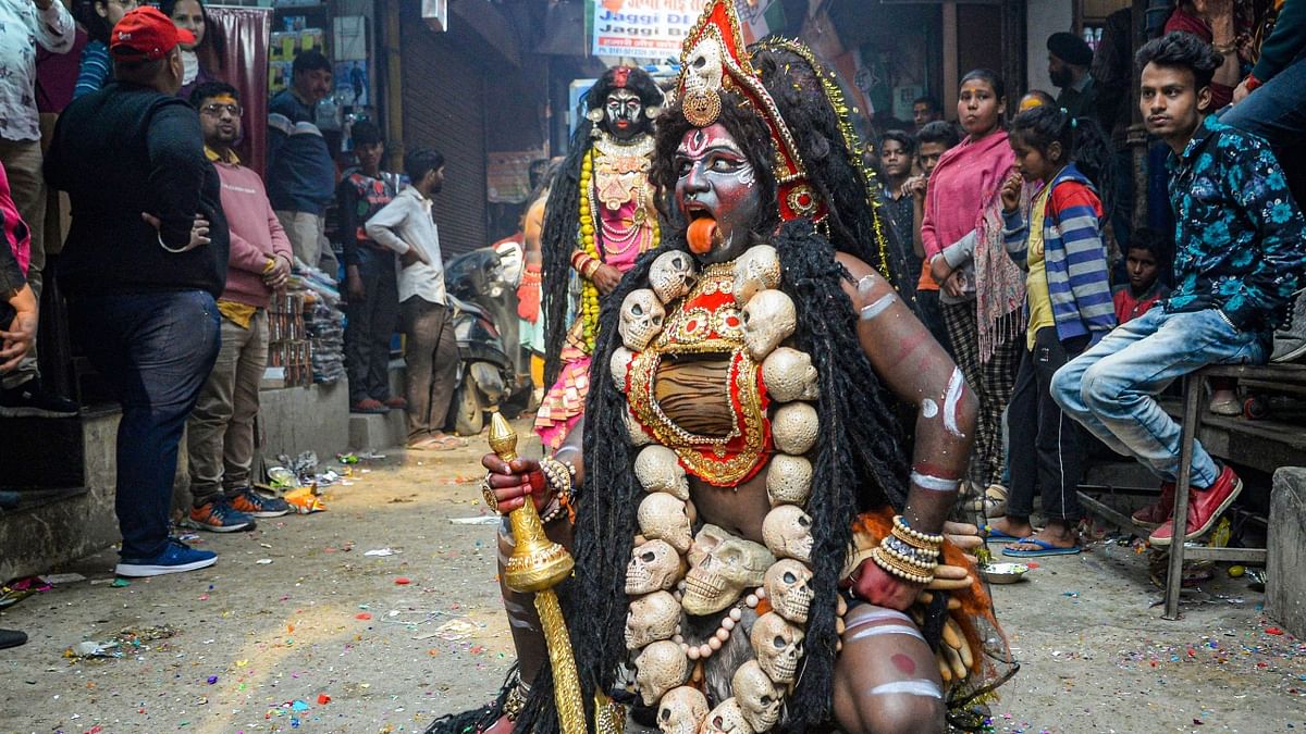 An artist dressed as Goddess Kali performs an act during a religious procession in Jalandhar. Credit: PTI Photo