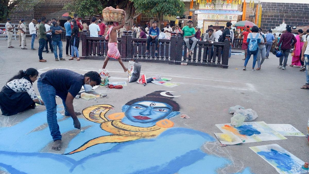 Artists make an art of Lord Shiva in front of Lord Lingaraj temple, on the eve of the Maha Shivaratri festival, in Bhubaneswar. Credit: PTI Photo