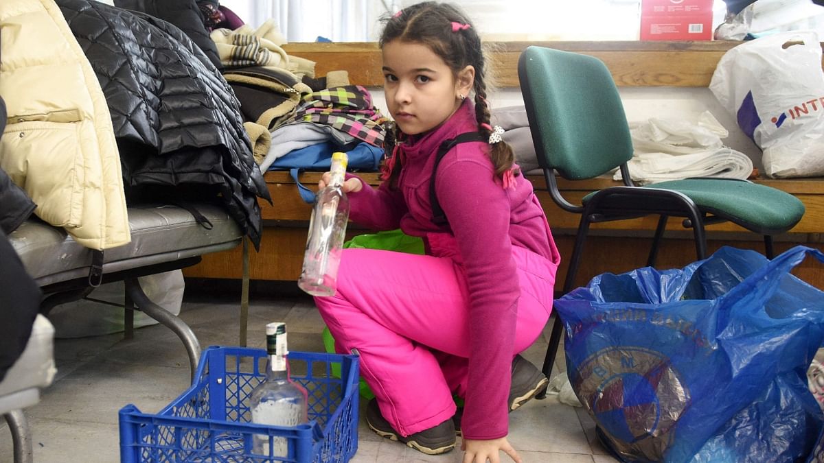 A small girl collects empty bottles for Molotov cocktails at a humanitarian centre in the western Ukrainian city of Lviv. Credit: AFP Photo