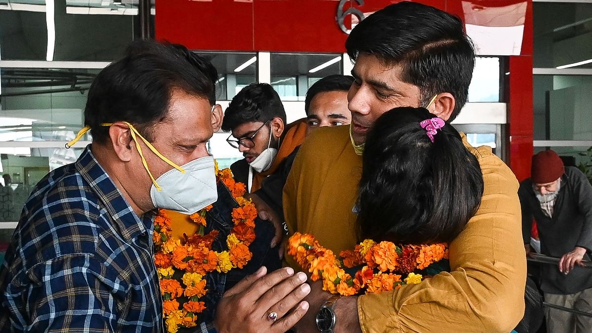 Family members receive a relative evacuated from Ukraine on a special flight. They welcomed them with a garland at Indira Gandhi International Airport in New Delhi. Credit: AFP Photo