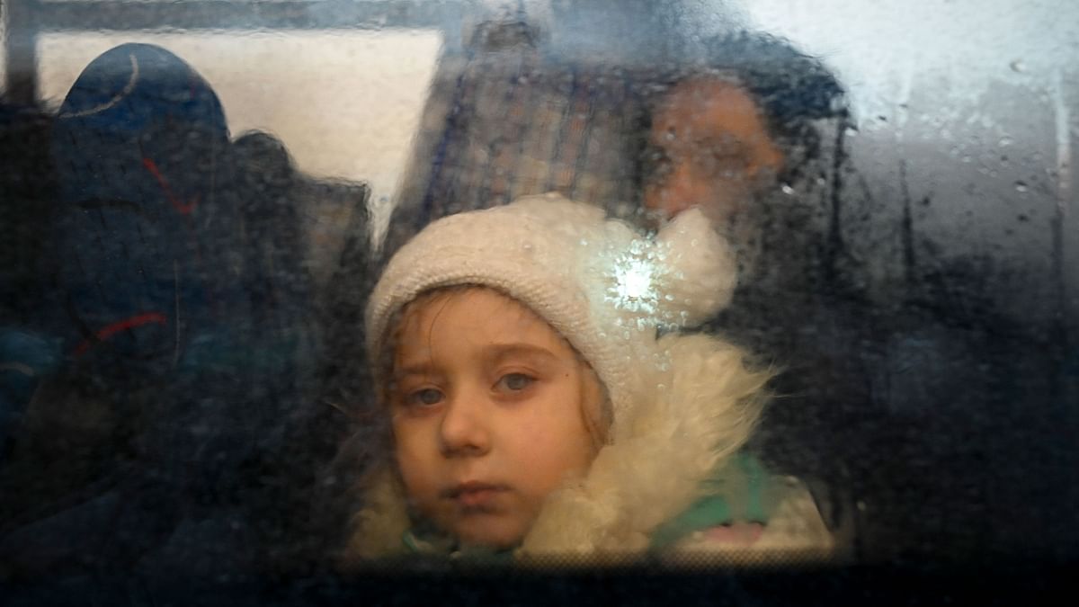 A girl fleeing the conflict in Ukraine looks on from inside of a bus heading to the Moldovan capital Chisinau. Credit: AFP Photo