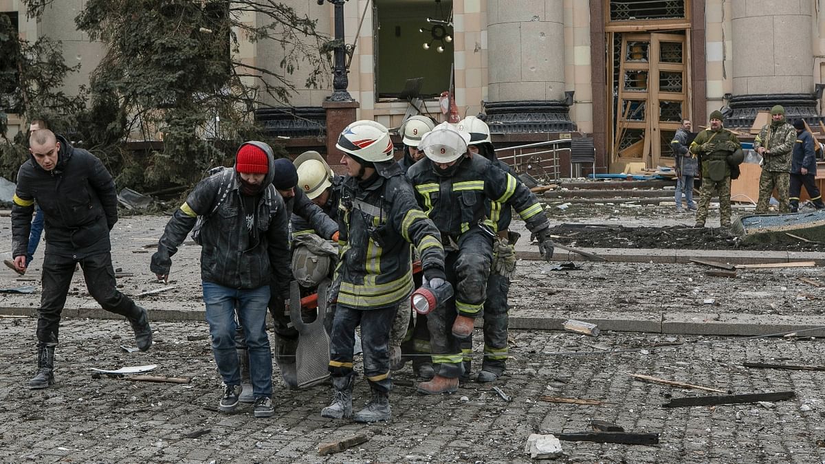 Ukrainian emergency service personnel carry a body of a victim out of the damaged City Hall building following shelling in Kharkiv, Ukraine. Credit: AP Photo
