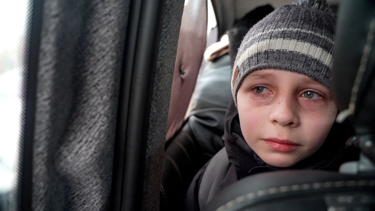 A young boy from Kyiv sheds tears as he talks about leaving his father behind as he travels with the rest of his family towards the border, following Russia's invasion of Ukraine, in Volytsia, Ukraine. Credit: Reuters Photo