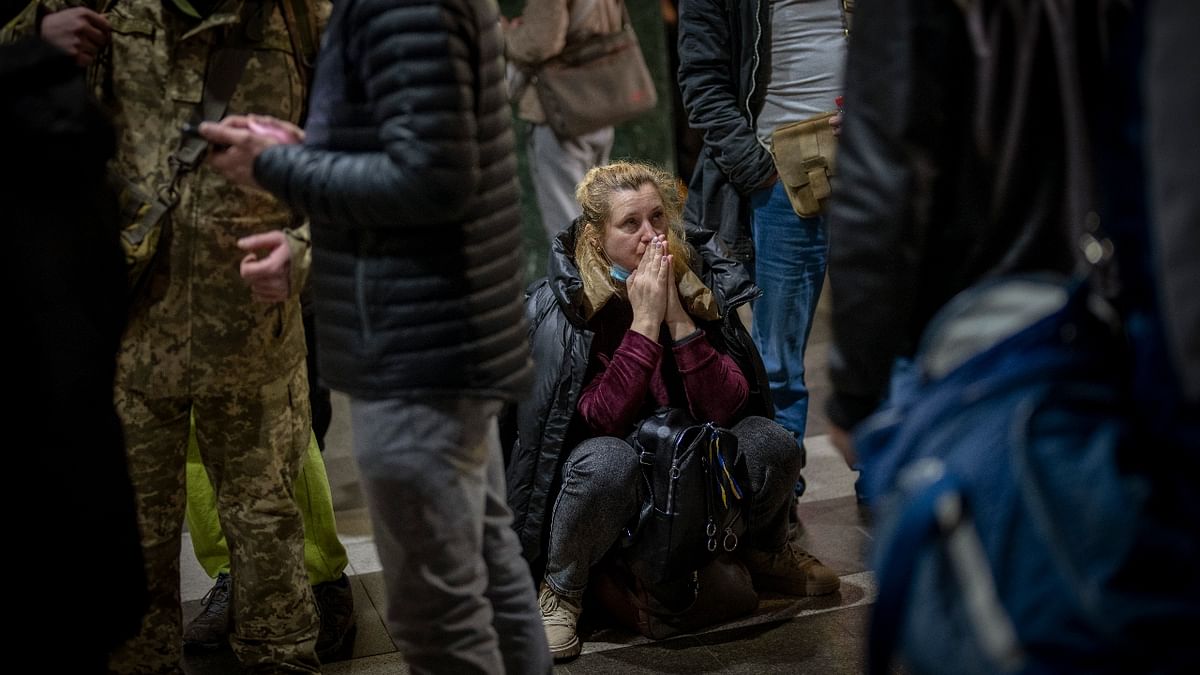 A woman is captured in a pensive mood as she waits for a train trying to leave Kyiv, Ukraine. Credit: AP Photo