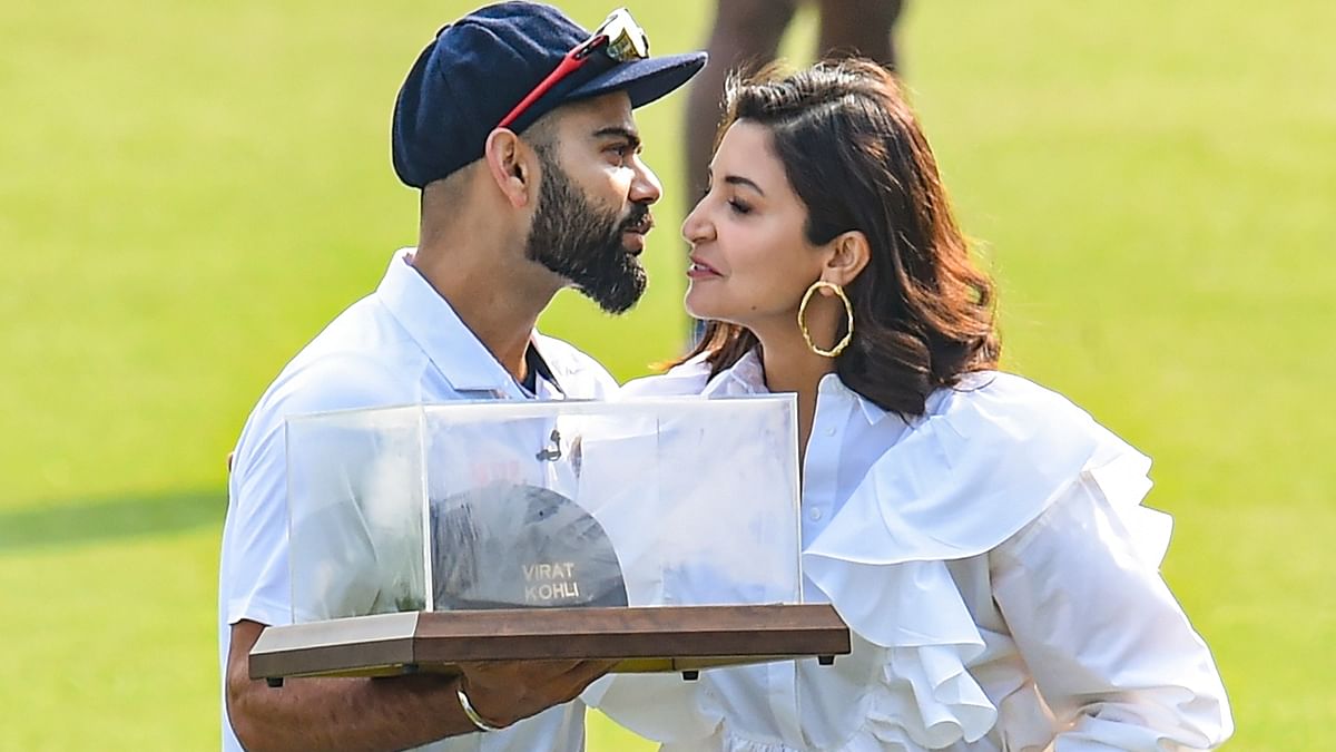 Virat Kohli poses with his wife Anushka after being honoured by the Punjab Cricket Association (PCA) for becoming the 13th Indian cricketer to play 100 Test matches at IS Bindra PCA Stadium in Mohali. Credit: PTI Photo
