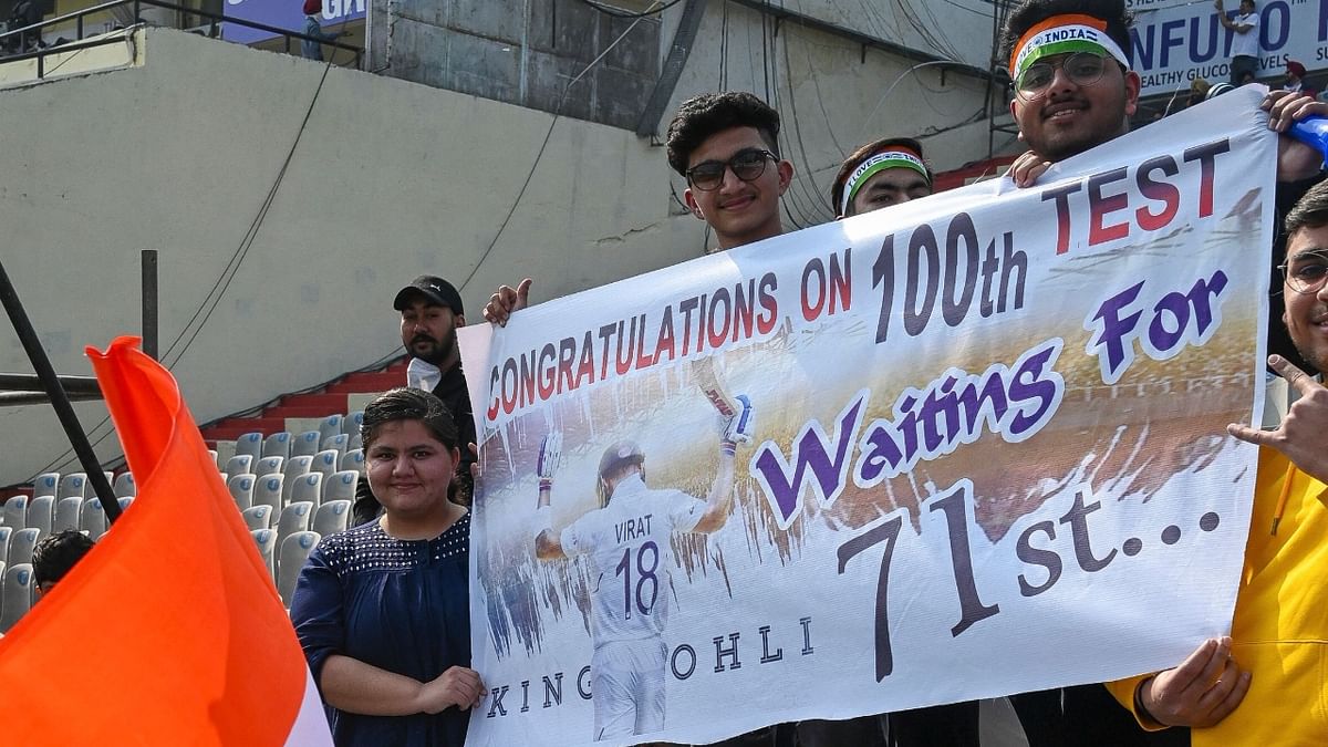 Fans and well-wishers of Kohli are seen holding a placard while cheering for him during the first Test cricket match between India and Sri Lanka at the Punjab Cricket Association Stadium in Mohali. Credit: AFP Photo