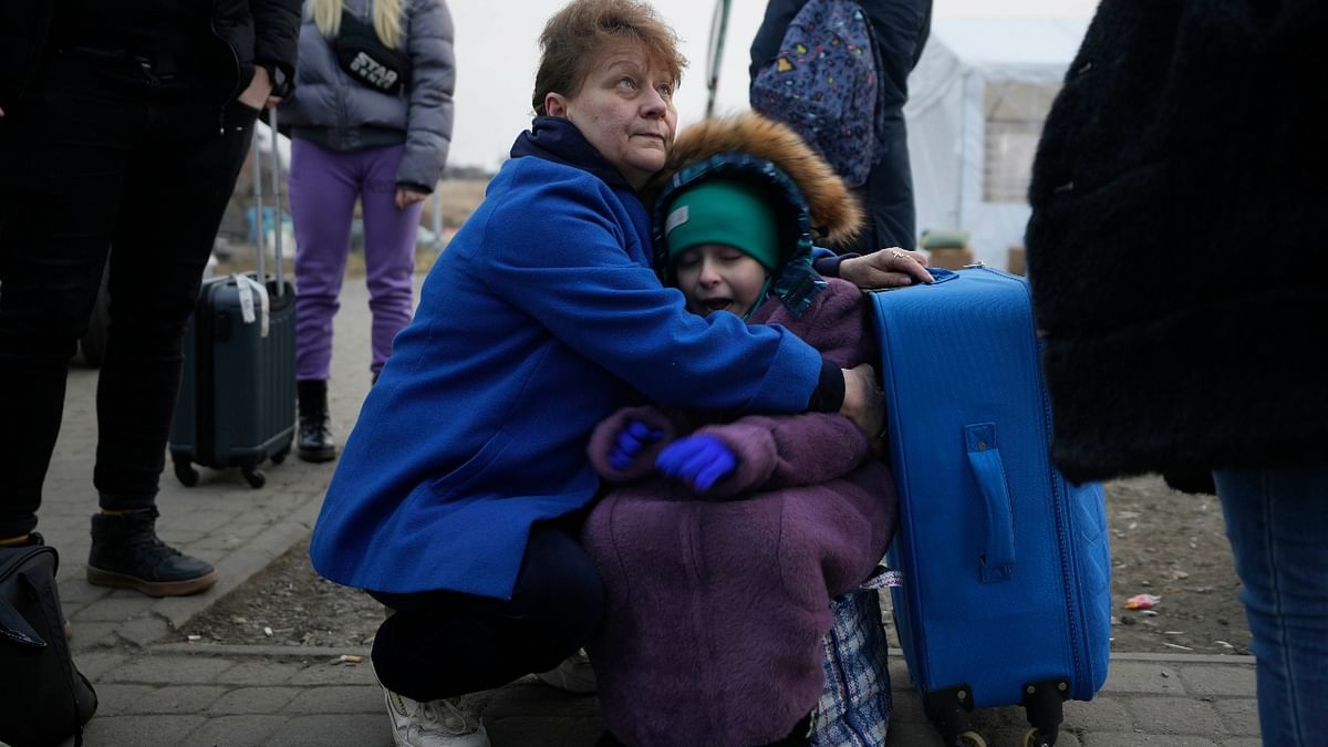 A woman holds a small girl at a border crossing, up as refugees flee a Russian invasion, in Medyka, Poland. Credit: AP Photo