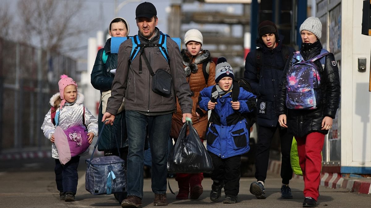 A group of people walk after fleeing from Russia's invasion of Ukraine, at the border crossing in Sighetu Marmatiei, Romania. Credit: Reuters Photo