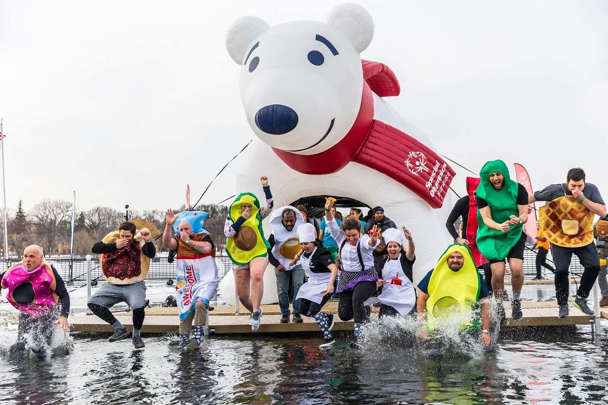 People in costumes jump into the water during the Minnesota Polar Plunge at Lake Bde Maka Ska in Minneapolis, Minnesota. The Polar Plunge is a series of events where participants fundraise in support of Special Olympics Minnesota. Credit: AFP Photo