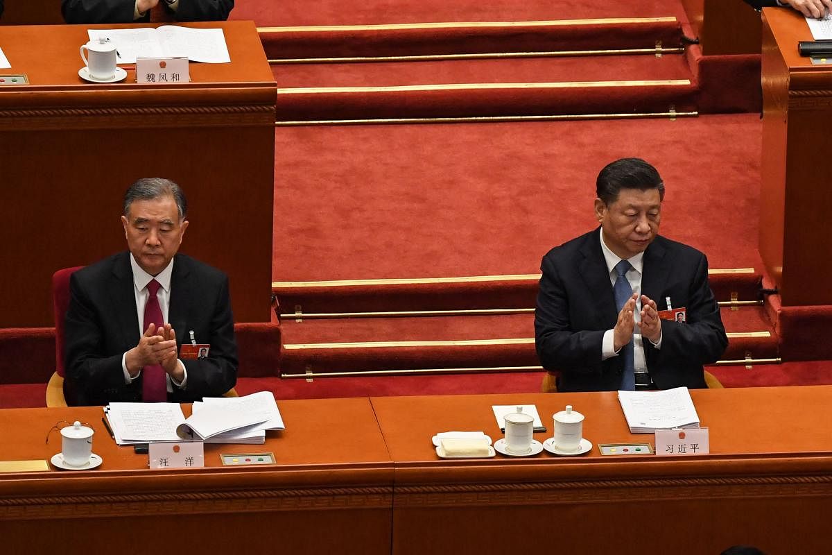 China's President Xi Jinping (R) and Politburo Standing Committee member Wang Yang applaud during the opening session of the National People's Congress (NPC) at the Great Hall of the People in Beijing. Credit: AFP Photo