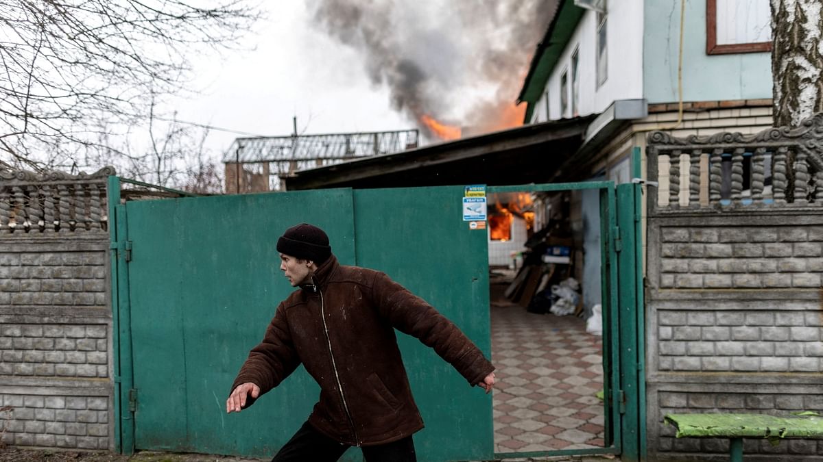 A local resident runs for his life as a house is on fire after heavy shelling by the Russian troops. Credit: Reuters Photo