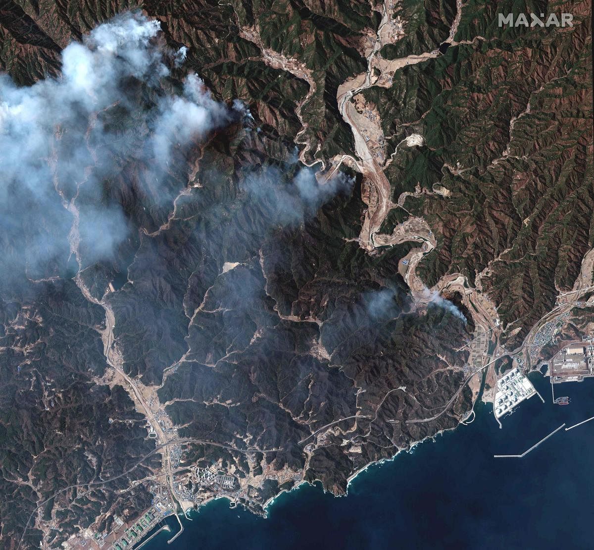 This handout satellite image released by Maxar Technologies shows a wildfire burning mountain forests in Samcheok, as a large wildfire torn through the country's eastern coastal region. Credit: AFP Photo