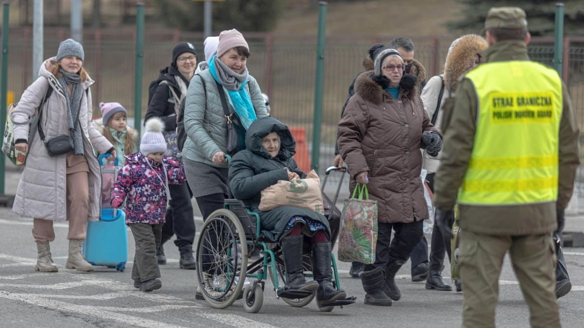 People arrive near a border checkpoint, after fleeing Russia's invasion of Ukraine, in Korczowa, Poland. Credit: Reuters photo