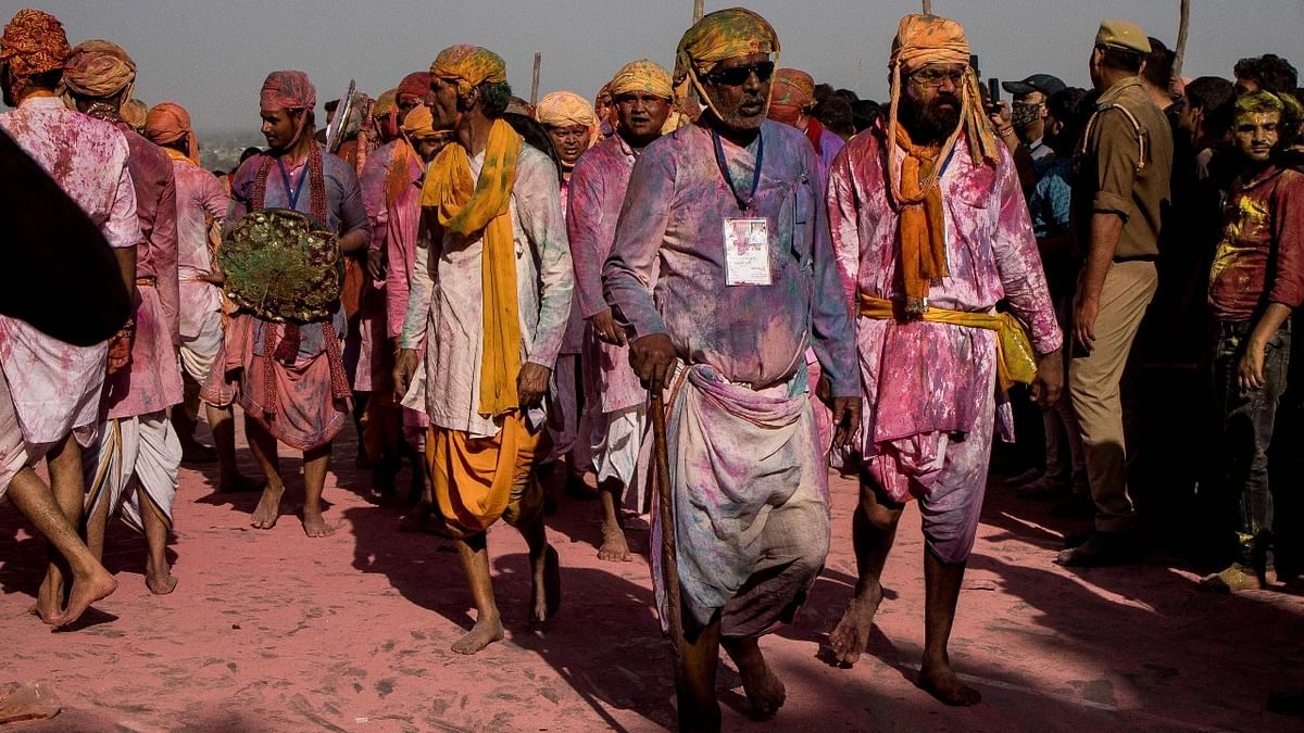 Revellers daubed in colours arrive at the Radha Rani temple to take part in Lathmar Holi celebrations. Credit: AFP Photo