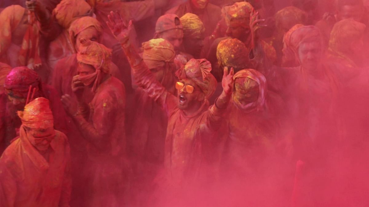People daubed with colours sing songs as they play Lathmar Holi at Nandgaon, in Mathura. Credit: PTI Photo