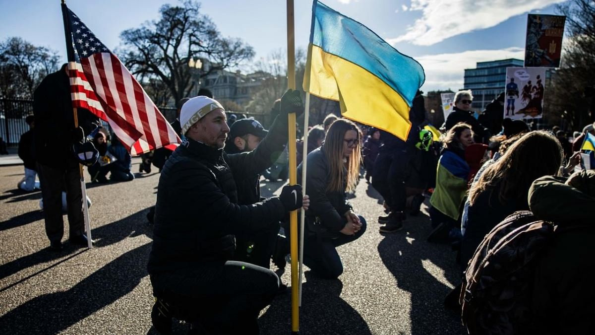 People take a knee during a moment of silence at a rally in support of Ukraine on Pennsylvania Ave in front of the White House in Washington, DC. Credit: AFP Photo