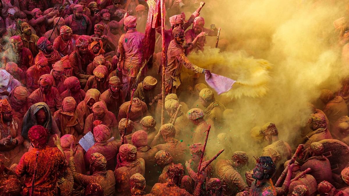 Revellers daubed in colours sing religious hymns during the Lathmar Holi celebrations at Nandgaon village in Uttar Pradesh. Credit: AFP Photo