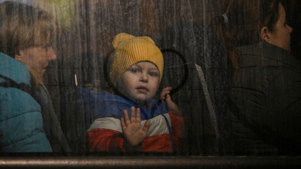 A child greets from the window of a bus after crossing the Ukrainian border with Poland at the Medyka border crossing, southeastern Poland. Credit: AFP Photo