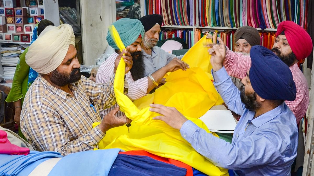 Bhagwant Mann urged men to wear 'basanti' (yellow) colour turbans and women to wear basanti 'dupatta'. In this photo, people are seen shopping for yellow colour turbans. Credit: PTI Photo