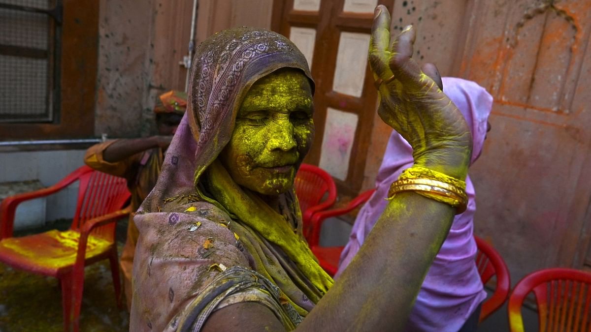 Smeared in colours, a widow is seen dancing during the Holi celebrations at a temple in Vrindavan. Credit: AFP Photo