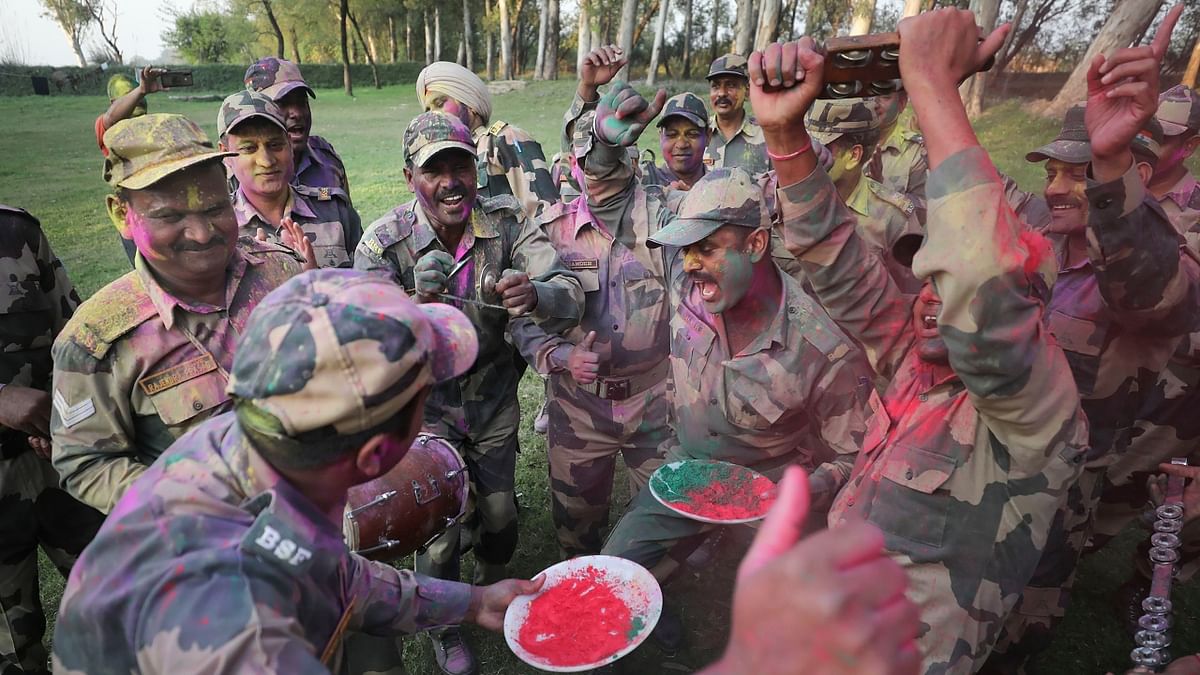 Border Security Force (BSF) soldiers sing songs and dance as they play Holi at the Indo-Pak border of Golpattan, in Jammu. Credit: PTI Photo