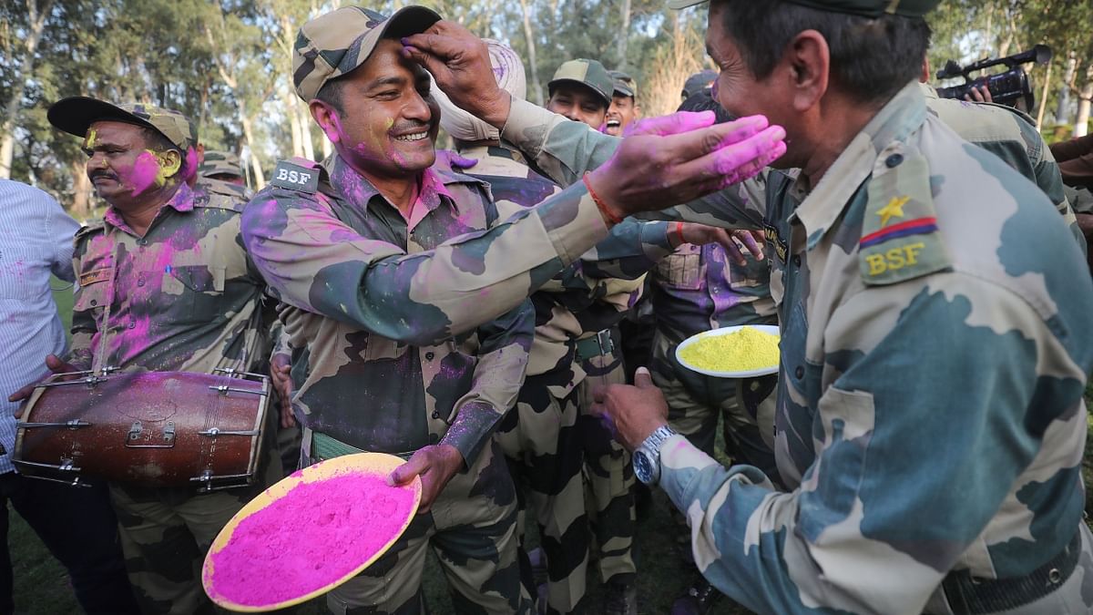 Border Security Force (BSF) soldiers apply colours as they celebrate Holi at the India-Pakistan border of Golpattan, in Jammu. Credit: PTI Photo